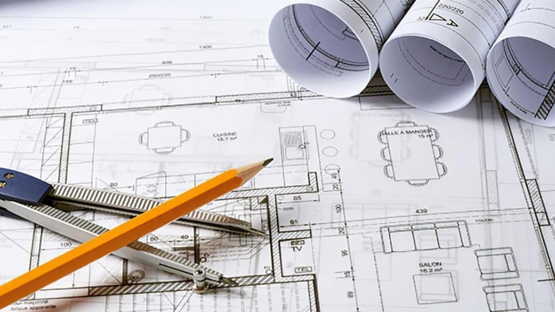 Un crayon et un compas reposent sur des plans d'architecture, trois plans enroulés se trouvant à proximité, présentant des dessins détaillés de l'agencement des bâtiments, y compris des pièces et de la disposition des meubles.